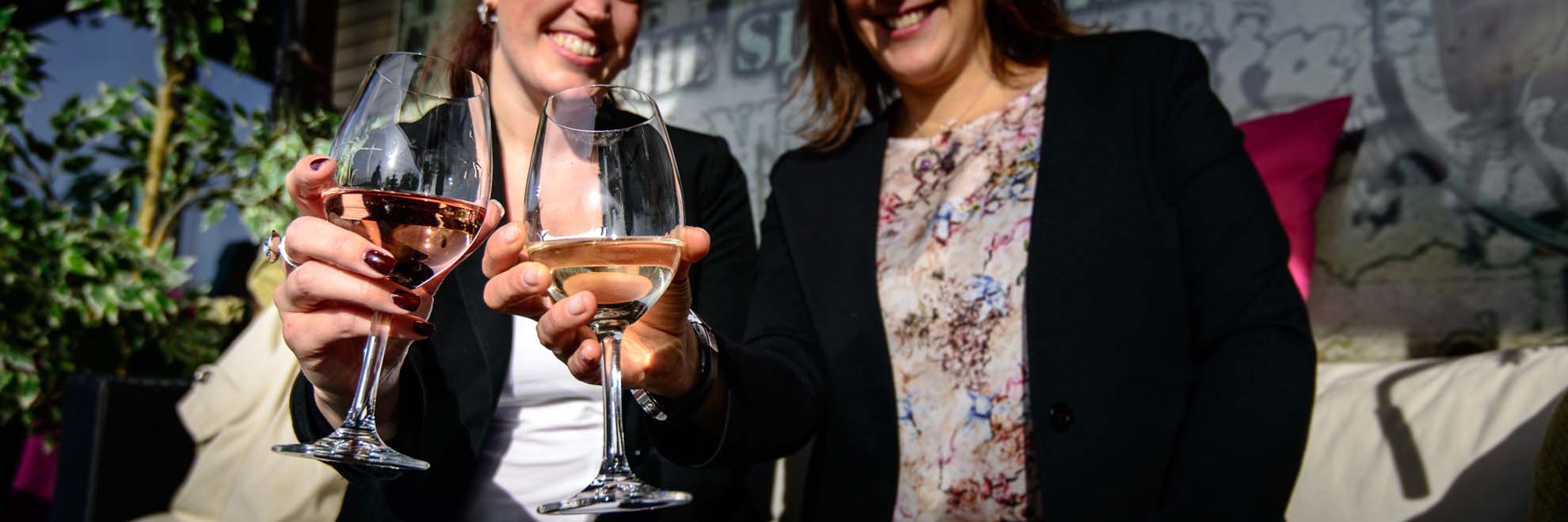 two women holding a glass of wine
